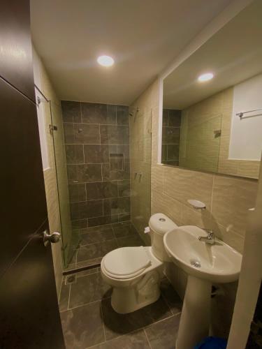 a bathroom with a toilet and a sink and a shower at Hotel Buenos Aires Central in Medellín