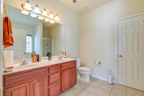 une salle de bain avec un lavabo, des toilettes et un miroir dans l'établissement 6 Mi to Charlotte Motor Speedway Home with Fire Pit, à Concord