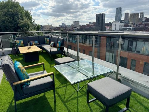 a balcony with chairs and tables on a roof at Luxury Penthouse with Private Hot Tub Overlooking Leeds City Centre in Leeds
