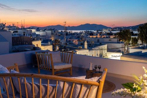 a balcony with two chairs and a view of a city at Casa DiVal by Divalproperties-Mykonos in Megali Ammos