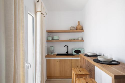 a kitchen with wooden cabinets and a sink and a counter at Casa DiVal by Divalproperties-Mykonos in Megali Ammos