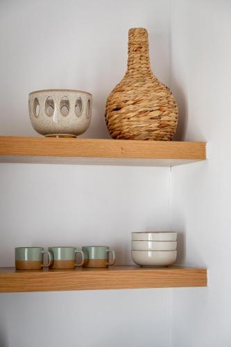 a shelf with bowls and vases on it at Casa DiVal by Divalproperties-Mykonos in Megali Ammos