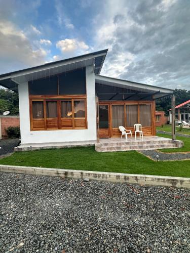 a house with two chairs in front of it at Eco Cabañas Montana in Santa Helena