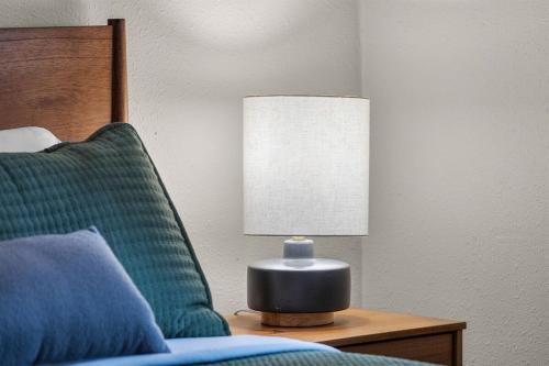 a lamp sitting on a table next to a bed at Hot Tub, Fire Pit, Dog Friendly, Heart of Sisters, Amenities in Sisters