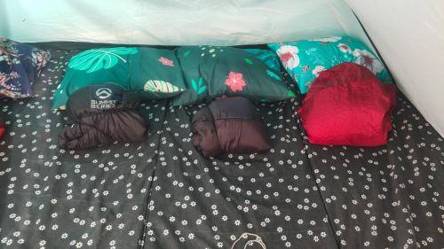 a comforter with pillows on top of a bed at Sentral Camp in Pengalengan
