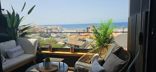 a balcony with two chairs and a view of the ocean at Dolce Waves Luxe Petit Déjeuner Jacuzzi Design et Vue Mer in Praia