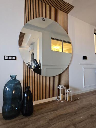 a mirror in a room with vases on the floor at Dolce Waves Luxe Petit Déjeuner Jacuzzi Design et Vue Mer in Praia