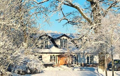 a house covered in snow with trees in front of it at 5 Bedroom Pet Friendly Home In Srokowo in Srokowo