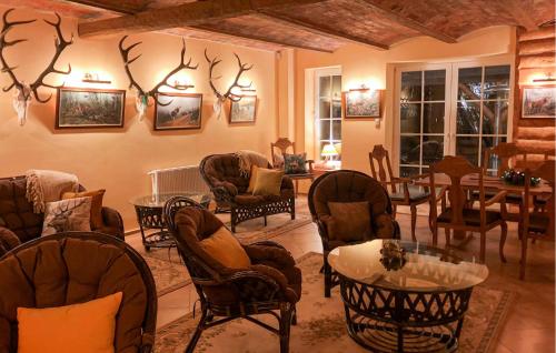 a living room with chairs and tables and antlers on the wall at 5 Bedroom Pet Friendly Home In Srokowo in Srokowo