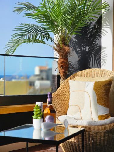 a coffee table with a palm tree in a room at Dolce Waves Luxe Petit Déjeuner Jacuzzi Design et Vue Mer in Praia