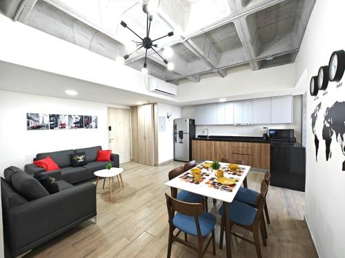 a kitchen and living room with a table and a couch at Lux 2 BR apartment, swimming pool, gym and free parking spot in downtown Monterrey in Monterrey