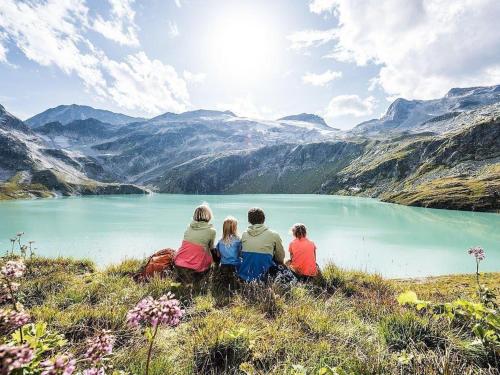 a group of people sitting on a hill overlooking a lake at FIIF Pinzgau in Wald im Pinzgau