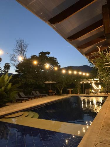a swimming pool in a backyard at night at Hotel el Ancla Campestre in Villeta