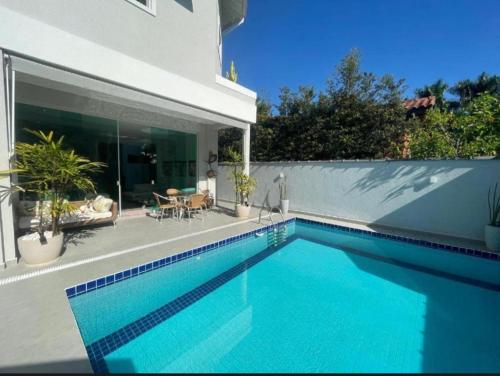 a swimming pool in front of a house at Casa com piscina 2 Guarujá enseada in Guarujá