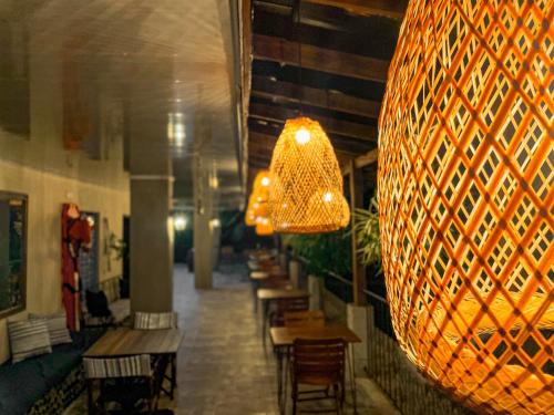 a large hanging light in a restaurant with tables and chairs at Hotel el Ancla Campestre in Villeta