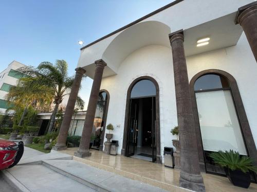 a white building with large windows and palm trees at Hotel Villa Montes in Ezequiel Montes