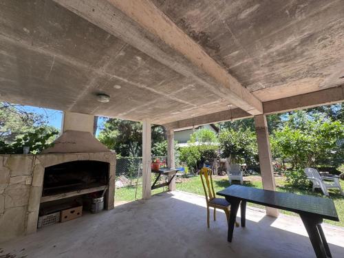 a patio with a table and a fireplace at CASA EN VALERIA DEL MAR Y PLAYA in Valeria del Mar