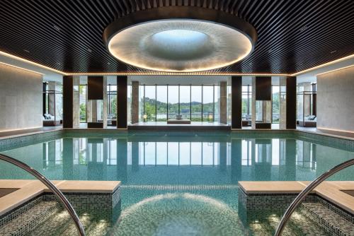 a large swimming pool with a large ceiling at 紫云玄清酒店 ZiYunXuanQing Resort&Spa 