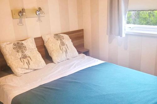 une chambre avec un lit avec deux oreillers dessus dans l'établissement Bungalow charmant à Agde avec piscine partagée, à Agde