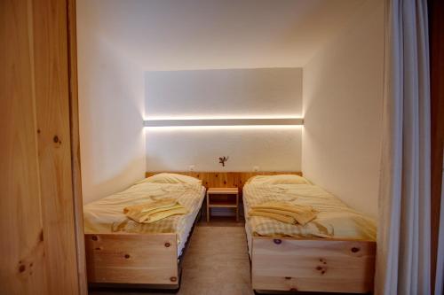two twin beds in a small room with at Chesa Munteratsch 1 1 2-Zimmerwohnung 209 Typ D in Silvaplana