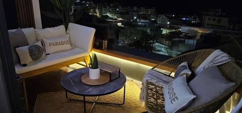a balcony with a couch and a table and a window at Dolce Waves Luxe Petit Déjeuner Jacuzzi Design et Vue Mer in Praia