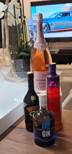 a bottle of gin and two bottles of honey on a table at Dolce Waves Luxe Petit Déjeuner Jacuzzi Design et Vue Mer in Praia