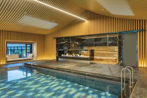 a swimming pool in a building with a fireplace at 紫云玄清酒店 ZiYunXuanQing Resort&Spa 
