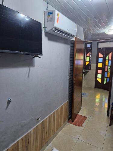 a wall with a flat screen tv on a wall at Kitnets com AR Condicionado na Praia in Salvador