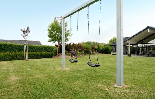 a playground with two swings in a yard at Gorgeous Home In Haderslev With Wifi in Haderslev