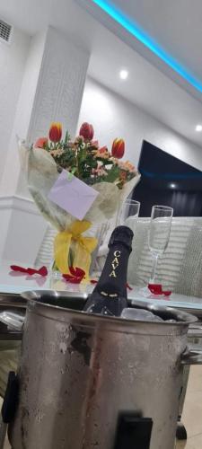 a table with a bowl of flowers and a bottle of wine at Oceanum Visum Spa Deluxe in El Trocadero