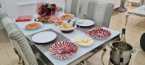 a table with plates of food and a bottle of wine at Oceanum Visum Spa Deluxe in El Trocadero