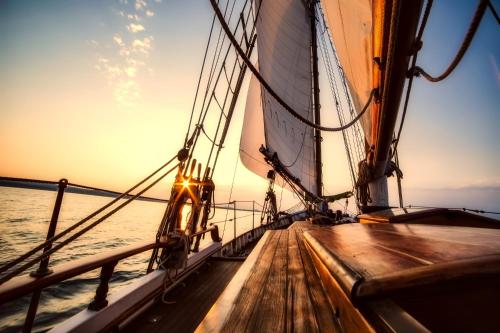 a sailboat in the ocean at sunset at Oceanum Visum Spa Deluxe in El Trocadero