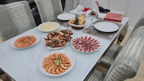 a white table with plates of food on it at Oceanum Visum Spa Deluxe in El Trocadero