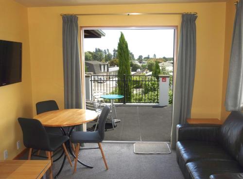 a living room with a table and a couch at Beachside Villas Motel in Nelson
