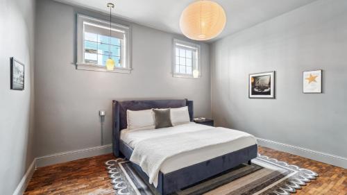 a bedroom with a bed and two windows at The Mary Beth Hotel & Gallery in New Orleans