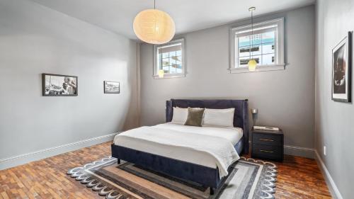 a bedroom with a bed and two windows at The Mary Beth Hotel & Gallery in New Orleans