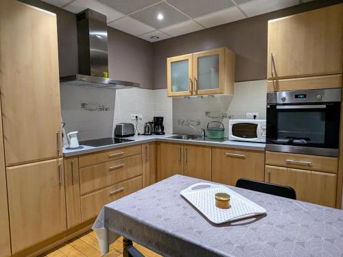 une cuisine avec des placards en bois et une table avec une tasse dans l'établissement Gîte 75m² avec WIFI et animaux acceptés à Montmédy - FR-1-585-23, à Montmédy