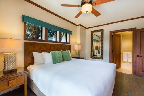 a bedroom with a white bed and a ceiling fan at Koloa Landing Resort at Po'ipu, Autograph Collection in Koloa