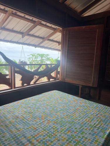 a room with a hammock and a bed and a window at La Bamba in Termales - agua caliente - nuqui