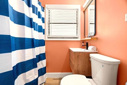 a bathroom with a toilet and a sink and a window at Boutique Beach Retreat in St Pete Beach