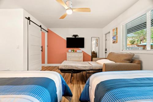 a bedroom with two beds and a flat screen tv at Boutique Beach Retreat in St Pete Beach