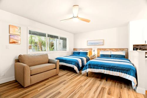 two beds in a room with a couch and a chair at Boutique Beach Retreat in St Pete Beach