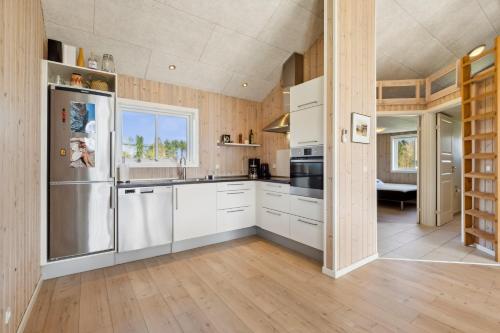 a kitchen with white cabinets and a stainless steel refrigerator at Modern Holiday Home From 2017, Located At Lild Strand in Frøstrup