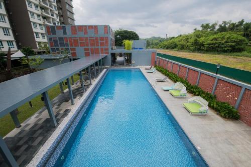 a swimming pool on top of a building with lounge chairs at The Moonlight Valley Sri Indah in Sandakan