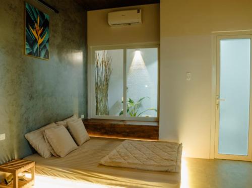 una cama en una habitación con una ventana grande en Villa Xứ Phan Vĩnh Hy, en Vĩnh Hy