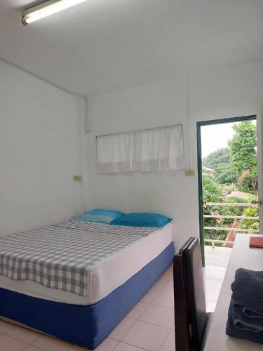 a bedroom with a bed and a sliding glass door at Ln House Chiang Mai in Chiang Mai