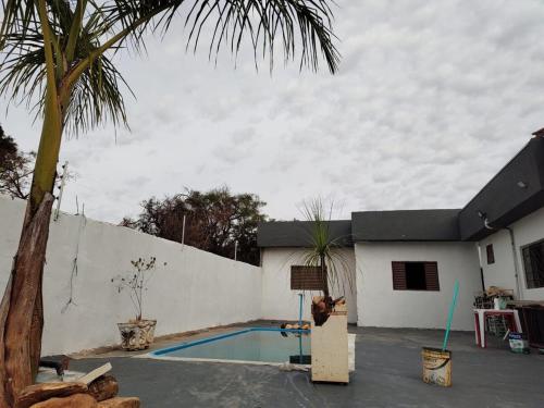 a house with a swimming pool and a palm tree at Area de lazer Vale do igapó Bauru in Bauru