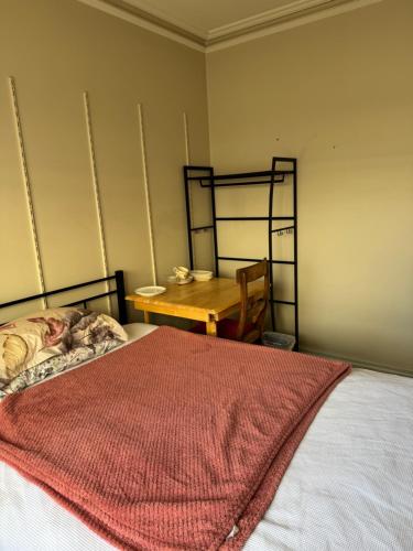a bedroom with a bed and a wooden table at Single room with shared bathroom 2 in Glen Waverley