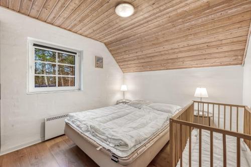 Un dormitorio con una cama grande con techo de madera. en Renovated Thatched Pool House By The North Sea For 16 People, en Ulfborg