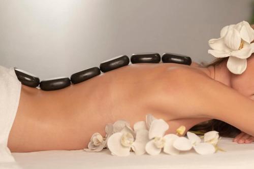 a woman wearing a black bikini with flowers on her back at Oceanum Visum Spa Deluxe in El Trocadero